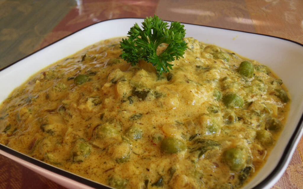  Methi Malai Matar served in a bowl and garnished with coriander leave