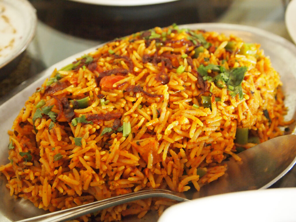 Veg Biryani garnished with fried onion and coriander leaves served in a plate 